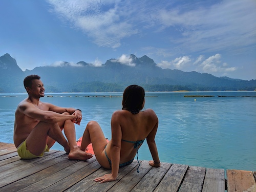 couple sitting on floating bungalows at khao sok national park