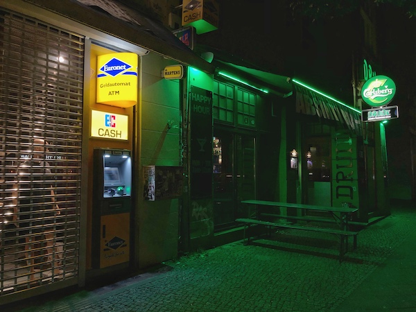 a euronet atm in berlin germany next to a bar at night