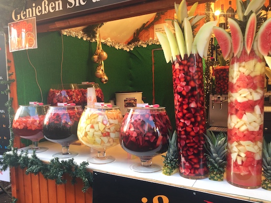 large wine glasses with red and white wine punch and pieces of fruit in it at a food stall in germany