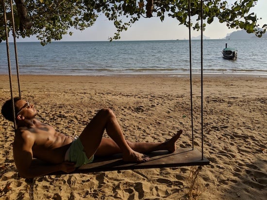man relaxing on a swing on the best beach in krabi