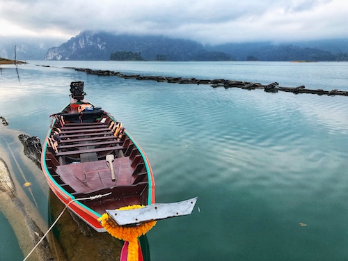 long tail boat floating on a lake in khao sok national park