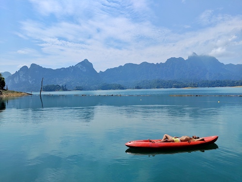 man lying in kayak in thailand is a great family vacation destination