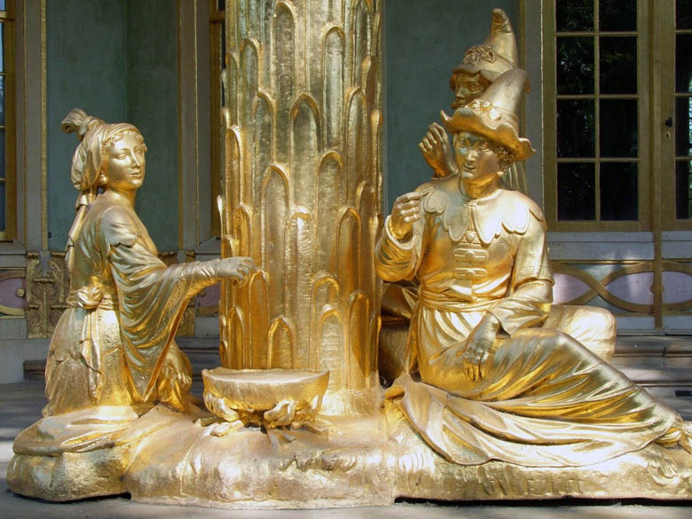 asian looking sculptures gilded in gold outside the chinese house in sanssouci is a top thing to see in potsdam on a day trip from berlin