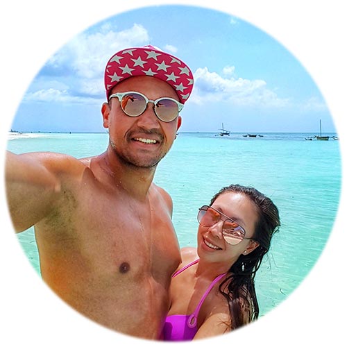 Michael and Chloe from Nomad And In Love taking a selfie on a beach in Zanzibar
