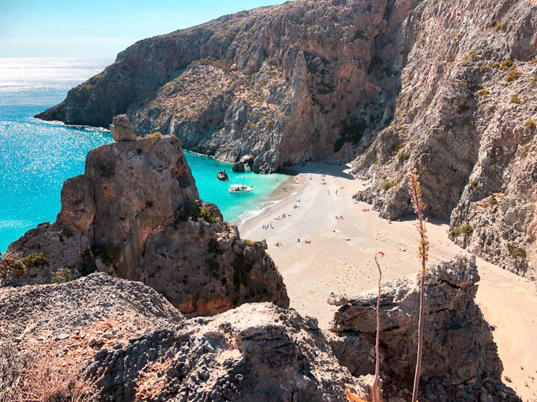 two dramatic cliffs standing on either side of a secret beach in crete with the clearest water at agiofarago 