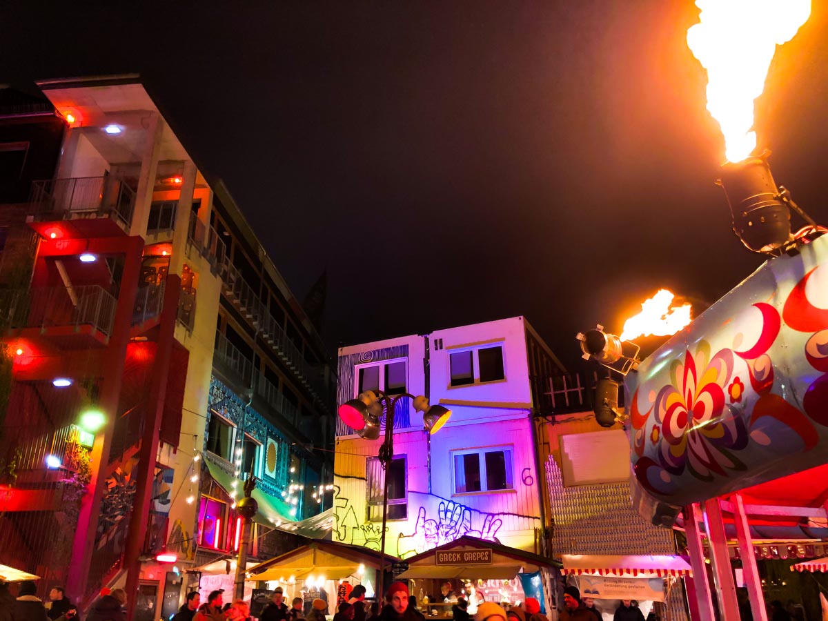 colorful lights illuminate food stalls and shops at the outdoor christmas market in holzmarkt berlin near jannowitzbrucke 