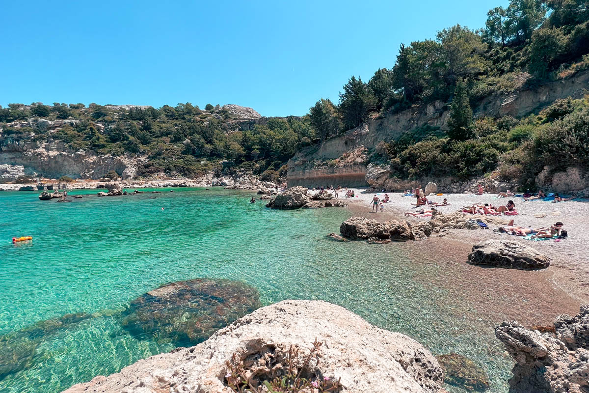 a narrow pebble beach with crystal clear turquoise blue waters on an island in greece 