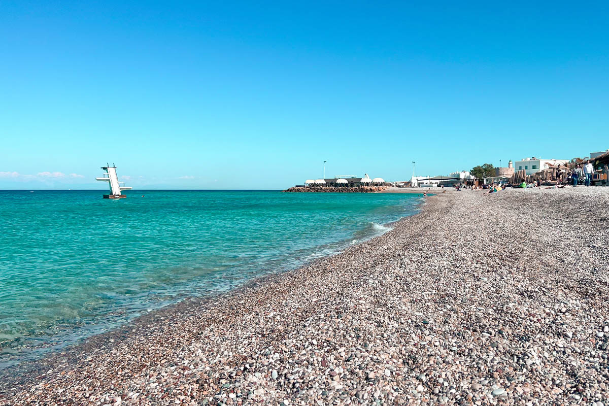 the pebble beach elli beach near old town rhodes with a diving platform in the background