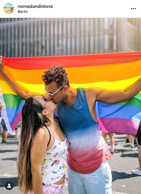 a couple kissing in front of rainbow pride flag at kurfurstendamm berlin germany gay pride festival