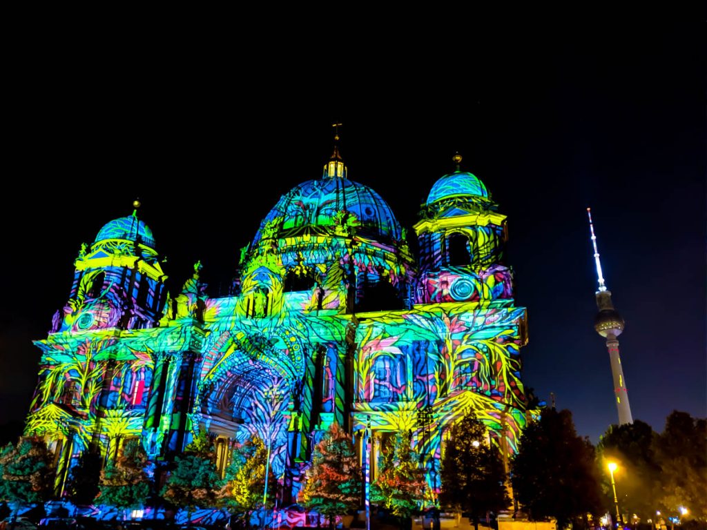 festival of lights in berlin with facade of berliner dom lit up in many colours