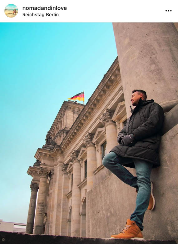 a secret photo spot at the reichstag building in berlin with a german flag against a blue sky