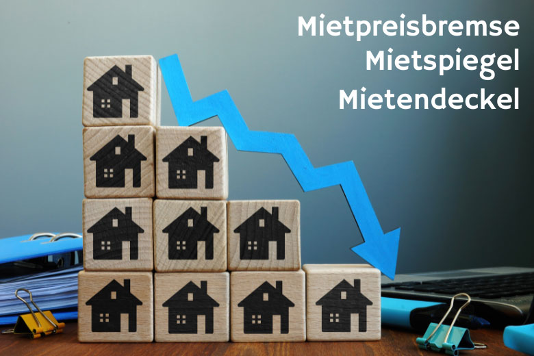 building blocks each with an imprint of a house neatly stacked on a desk in descending order with a decrease arrow positioned next to them and the words Mietpreisbremse, Mietspiegel and Mietendeckel written next to it