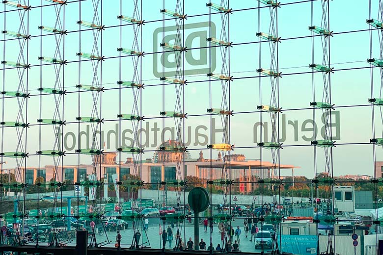 a view from inside looking outside through the glass wall of a busy Berlin Hauptbahnhof Central Station in Germany