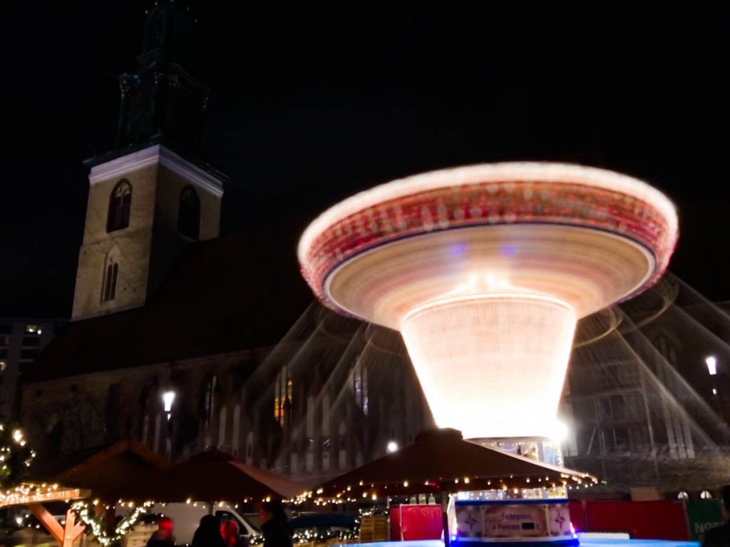 a traditional german christmas market in berlin with a bright carousel shot in long exposure mode