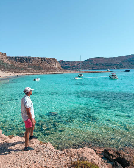 candid photography of a man at gramvousa island in crete with yachts and boats floating on the sea