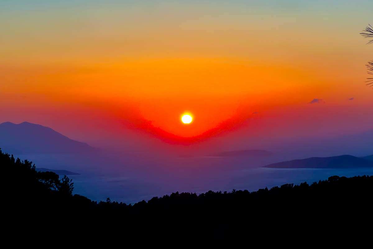 a gorgeous red orange sunset from a viewpoint in embonas rhodes