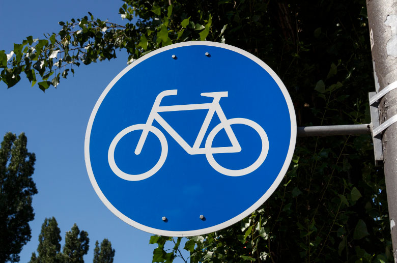 a blue traffic sign with a white bicycle on it in europe