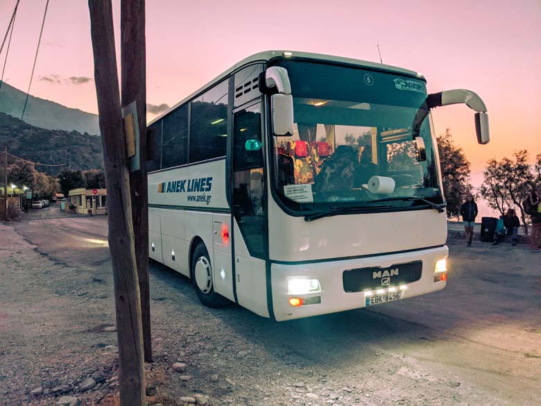 a white ktel bus in crete that is taking hikers from sougia to samaria gorge at dawn