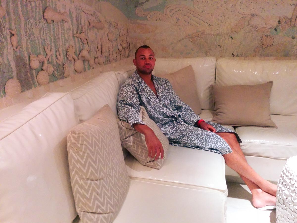 a man sitting in a white and blue spa robe at the twelve apostles luxury hotel and spa in cape town