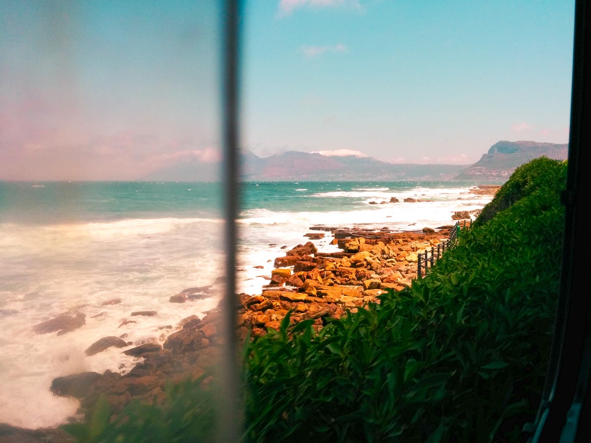 artistic photo shot of the ocean facing simon's town through an open window during a road trip