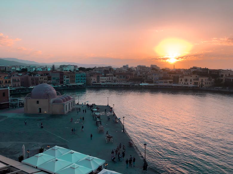 sunset at chania old town with a view over the famous venetian port and mosque on the edge of the water