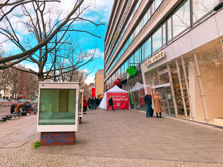 a long queue of people wearing masks standing in front of a pharmacy in Berlin for corona testing