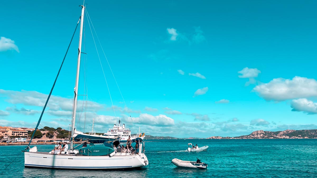 a white sailing boat with tourists on aboard sailing from costa smeralda to la maddalena islands