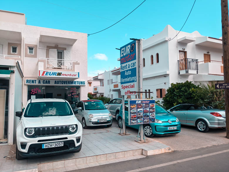 a local car rental shop in crete near stalis with different sized vehicles parked outside
