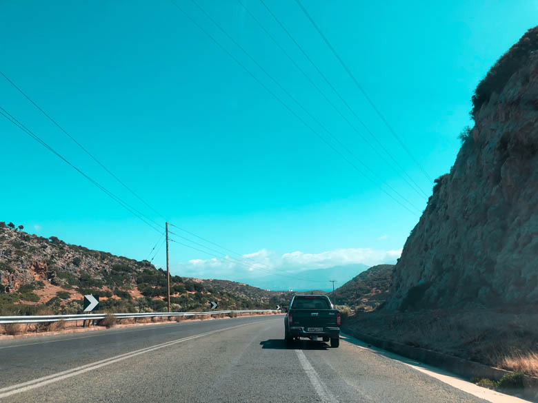 a black car driving on the right hand side of the road in crete greece