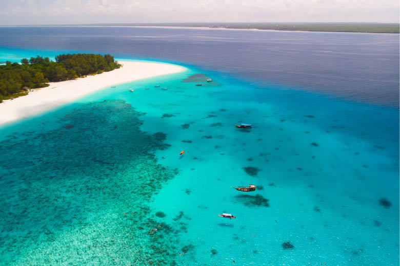 turquoise blue ocean around mnemba island in zanzibar with scuba diving boats floating