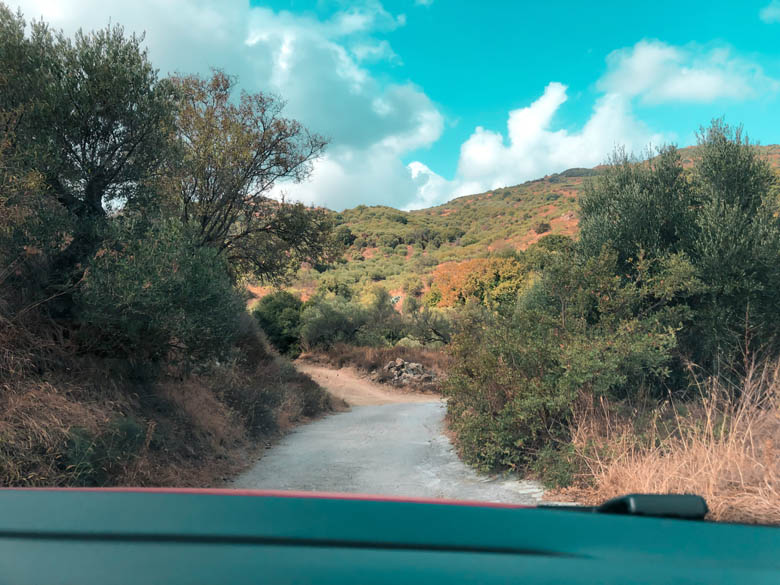 driving off road in Crete on a very narrow, unpaved dirt path wide enough to fit one car
