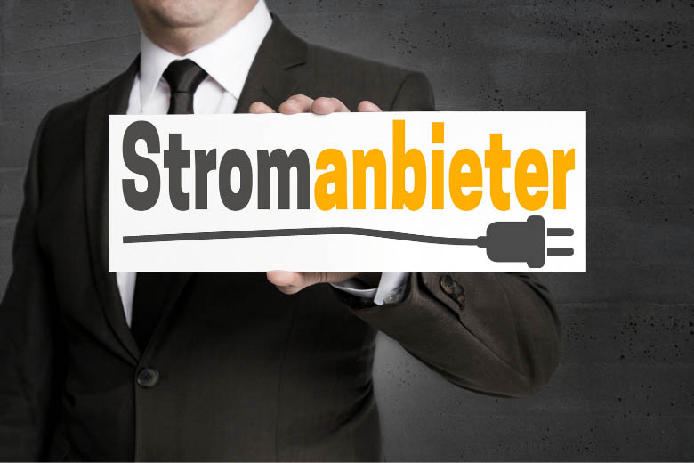 a man holding a sign with the german word 'stromanbieter' which means electricity provider in english