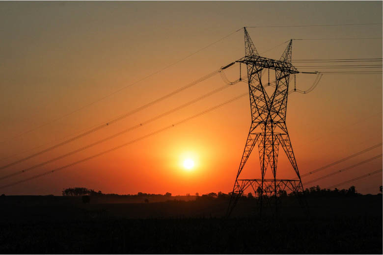 electricity power lines with orange sunset in the background