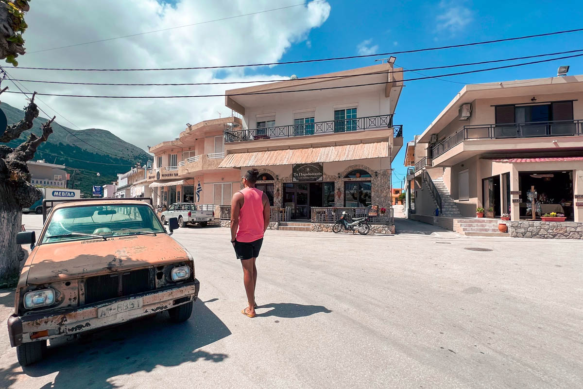 a man walking in an empty street in embonas mountain village in greece