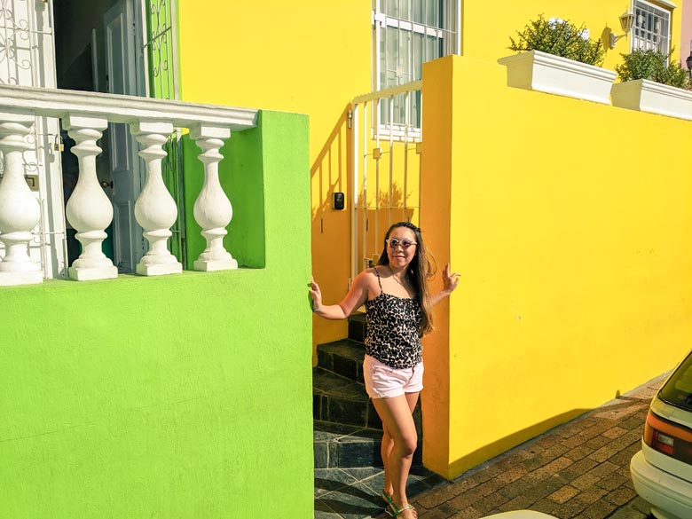 woman standing in front of colourful houses in bokaap cape town