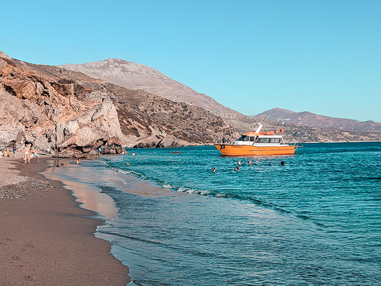 orange and white ferry taking people to preveli beach in crete