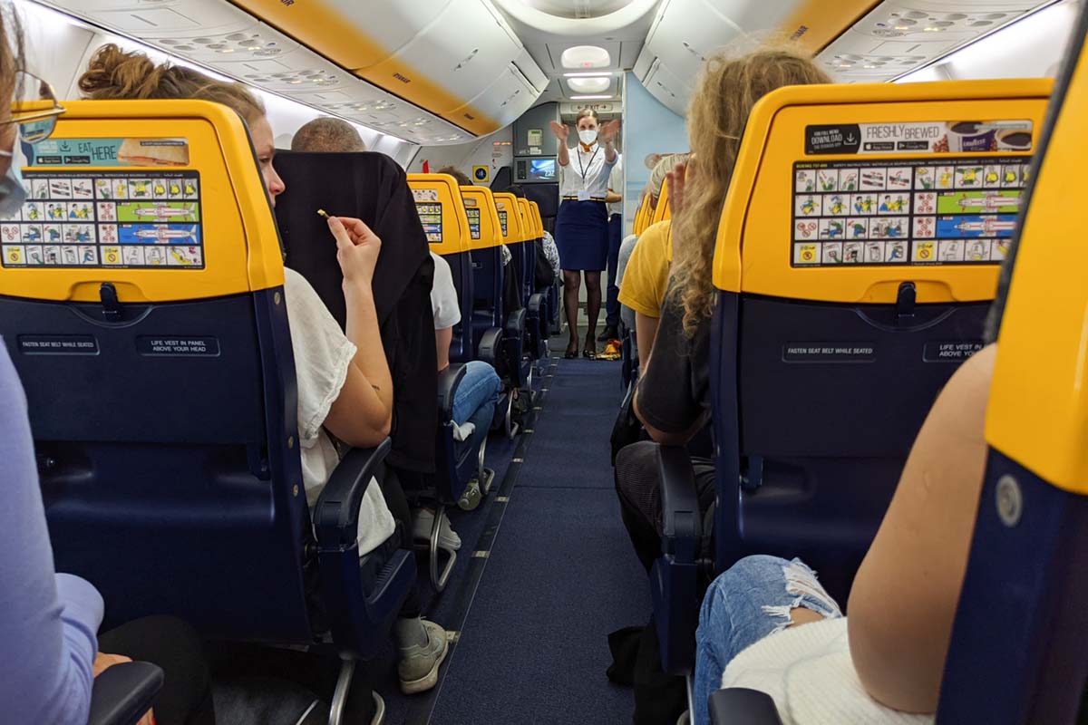 cabin crew demonstrating safety instructions inside a diverted Ryanair flight