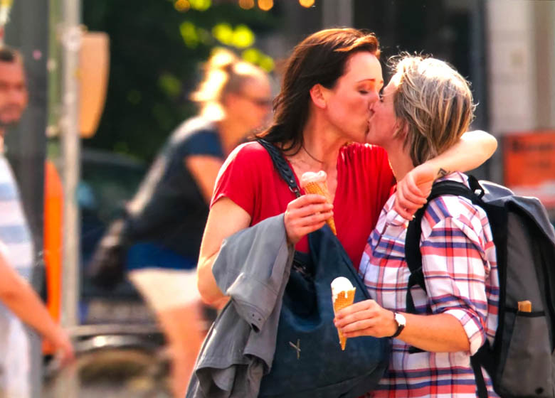 lesbian couple kissing with ice cream in hand in berlin capital of germany