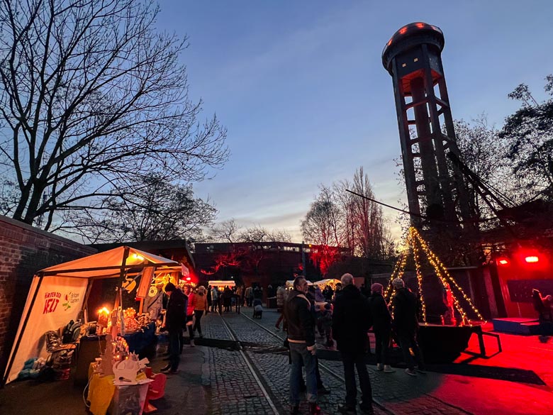 a small german advent market under a historic 50m high water tower in natur-park sudgelande in berlin