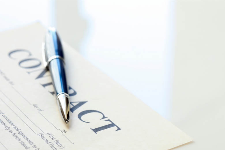 a dog adoption contract with a pen sitting on top on a white desk in germany