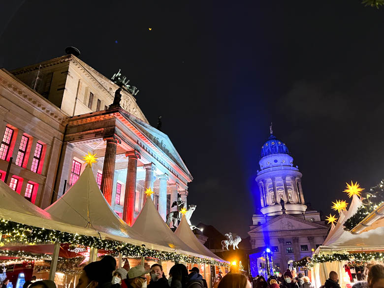a view of Gendarmenmarkt christmas market in berlin germany surrounded by the konzerthaus and deutscher dom