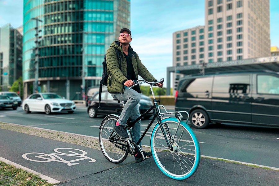 a man cycling along a bicycle lane on a Swapfiets bike at Potsdamer Platz in Berlin