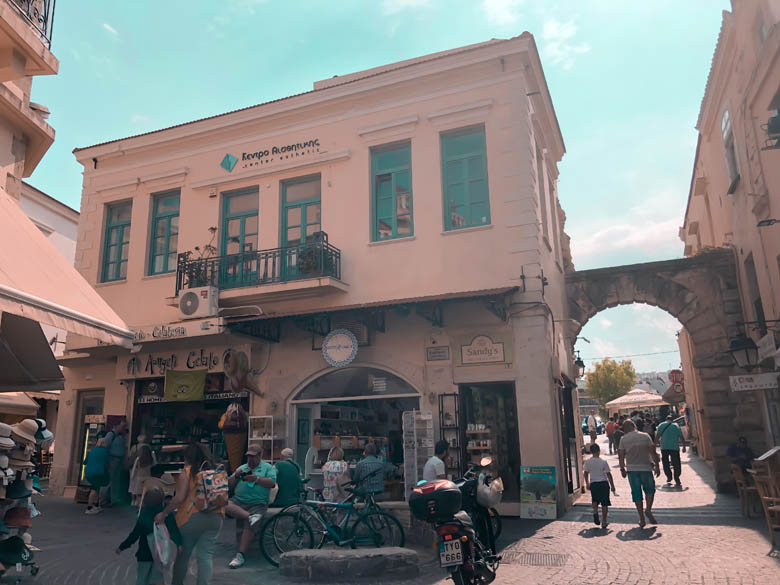 the bustling town center of chania with locals and tourists sitting and walking on the sidewalk 