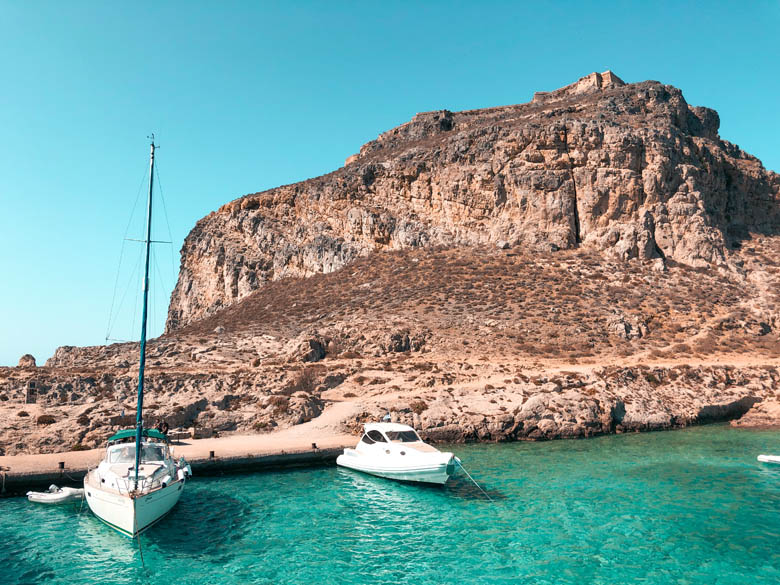 a 14th century venetian fortress on the highest point of gramvousa island with private boats and yachts floating on its crystal clear turquoise waters
