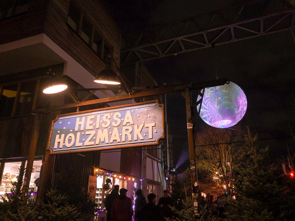 the entrance to heissa holzmarkt xmas market with a glittering disco ball in the background