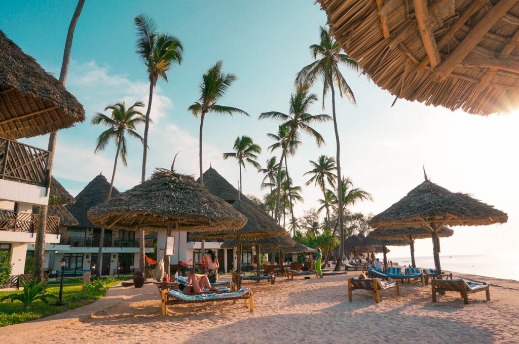 beach umbrellas and sun beds at an all inclusive resort on zanzibar beach