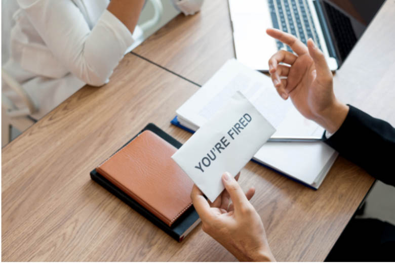 a person holding a piece of paper with the words you're fired written