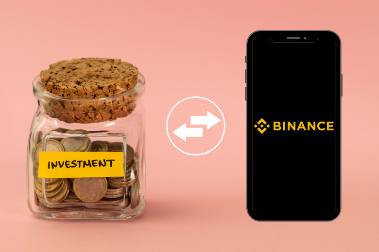 a glass jar filled with euro coins with the word investment written on it and on the right hand side a smartphone opening the investment app binance 