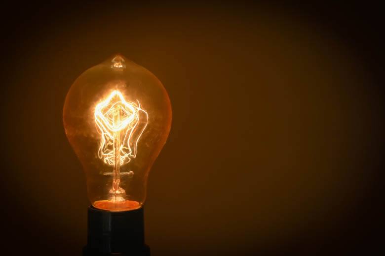 a light bulb switched on against a dark background