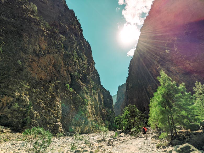 a man hiking alone in crete with two staggering cliffs on both sides